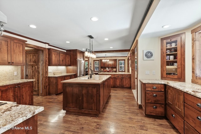 kitchen with recessed lighting, dark wood-style flooring, a sink, decorative backsplash, and an island with sink