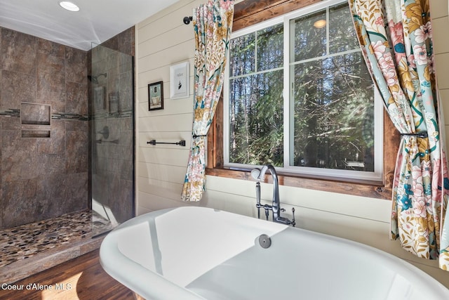 full bathroom featuring a freestanding bath and a tile shower