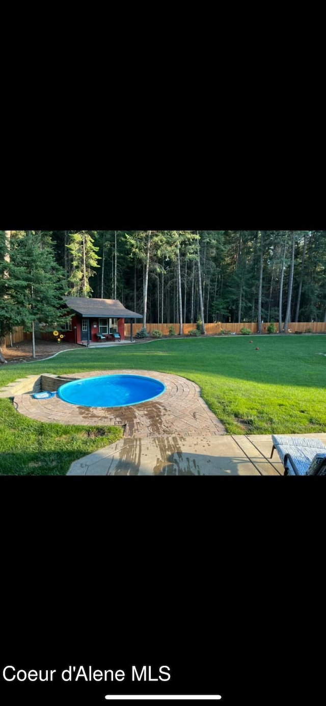 view of home's community featuring an outbuilding, a yard, and a wooded view