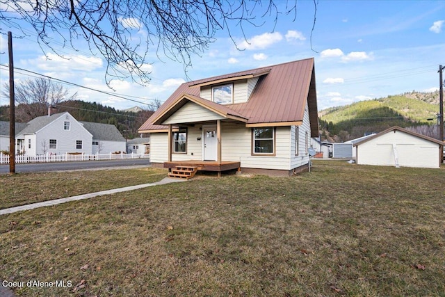 bungalow-style home featuring a porch, a front yard, metal roof, and fence