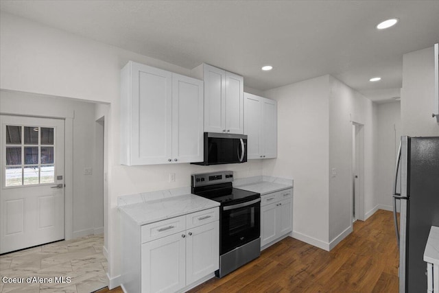 kitchen with baseboards, white cabinetry, stainless steel appliances, and recessed lighting