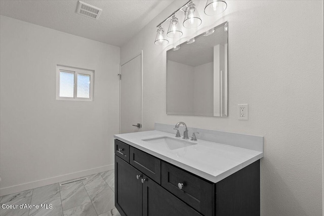 bathroom with a textured ceiling, vanity, visible vents, baseboards, and marble finish floor