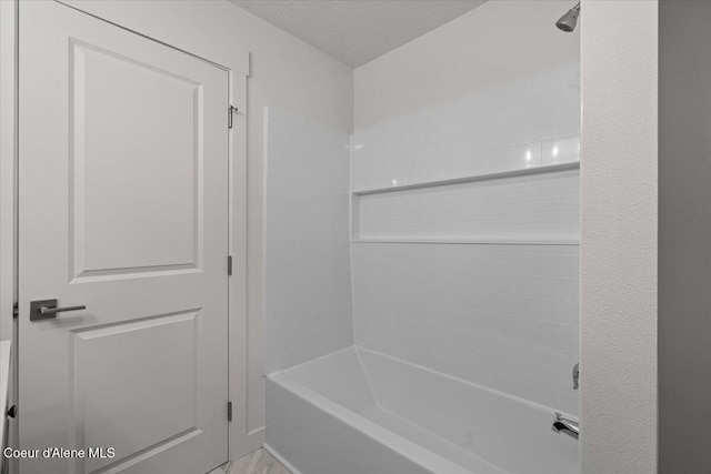 bathroom featuring a textured ceiling and shower / bathtub combination