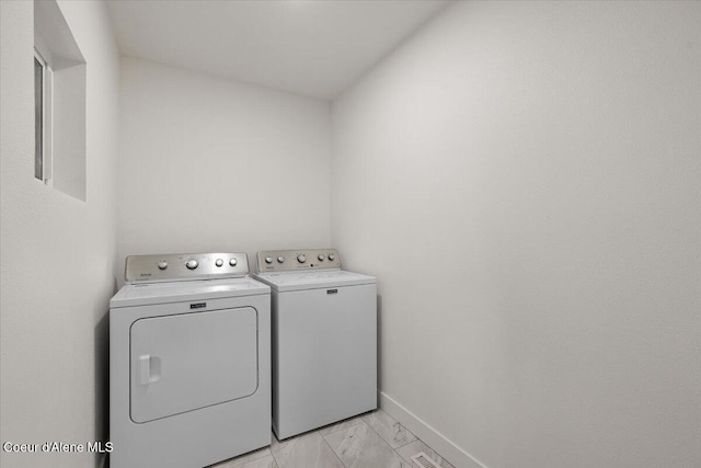 laundry room with washing machine and dryer, laundry area, marble finish floor, and baseboards