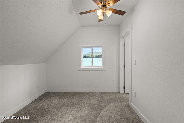 bonus room featuring lofted ceiling, carpet flooring, a textured ceiling, and baseboards