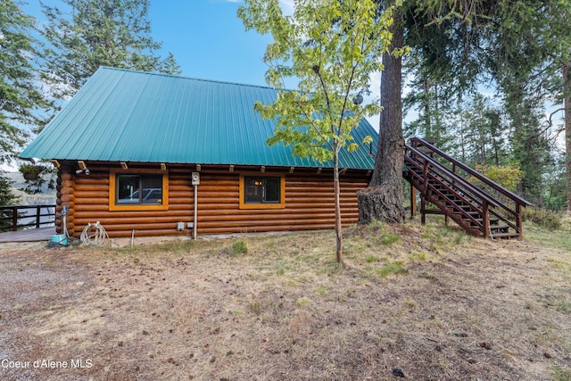 view of side of property with metal roof, stairway, and log siding