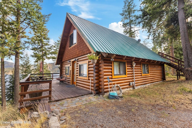 view of home's exterior featuring a deck, metal roof, and log siding