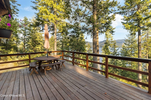 deck featuring outdoor dining area and a mountain view