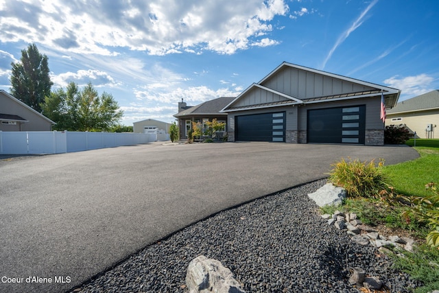 view of property exterior with stone siding, board and batten siding, and fence