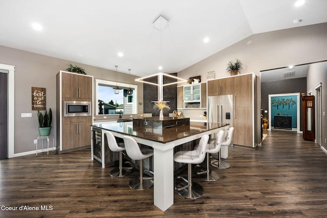 kitchen featuring a center island, dark wood-type flooring, a breakfast bar, lofted ceiling, and stainless steel appliances