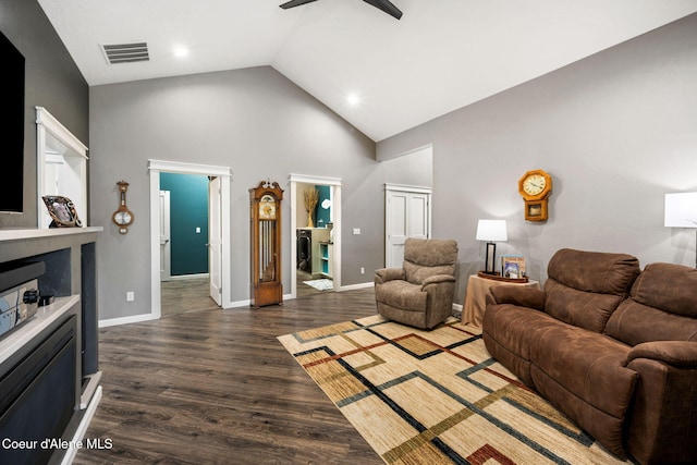 living area with visible vents, baseboards, high vaulted ceiling, and wood finished floors