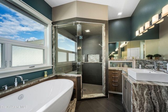 full bath featuring vanity, a shower stall, a soaking tub, and tasteful backsplash