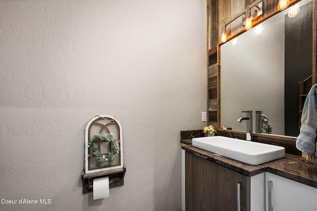 bathroom featuring vanity and a textured wall