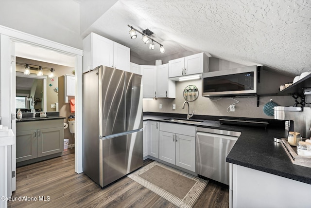 1222 W Tamarindo Ln, Hayden, ID 83835 - kitchen with a sink, stainless steel appliances, vaulted ceiling, a textured ceiling, and dark countertops
