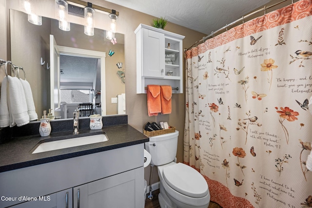 full bathroom featuring toilet, a textured ceiling, vanity, and curtained shower