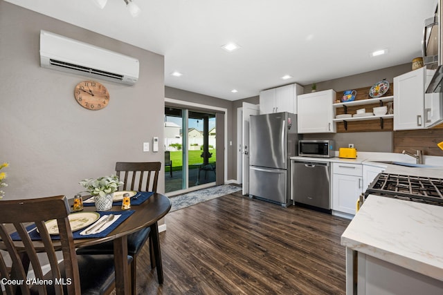 kitchen with dark wood-type flooring, stainless steel appliances, white cabinetry, a wall mounted AC, and open shelves