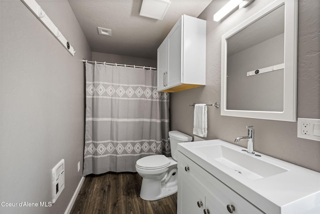 bathroom with visible vents, toilet, a textured ceiling, wood finished floors, and vanity