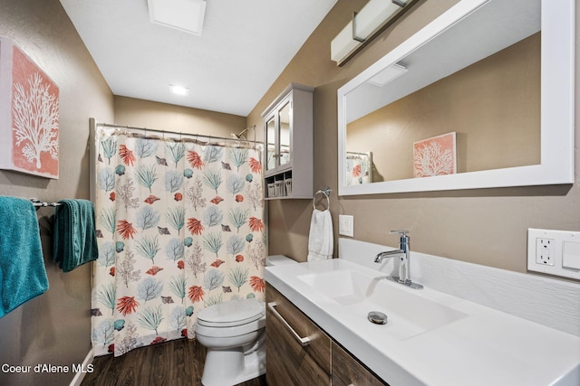 bathroom featuring curtained shower, toilet, vanity, and wood finished floors