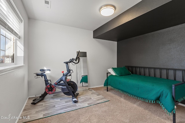 bedroom with carpet floors, visible vents, and baseboards