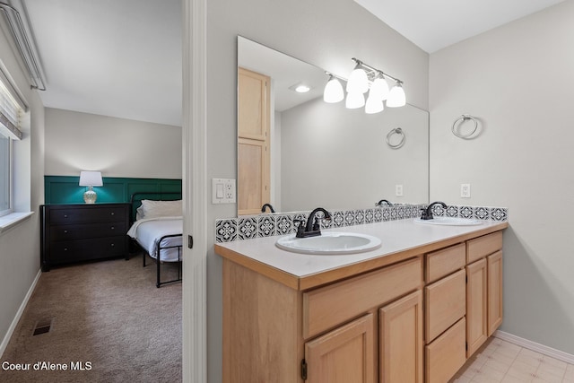 ensuite bathroom featuring double vanity, a sink, visible vents, and connected bathroom