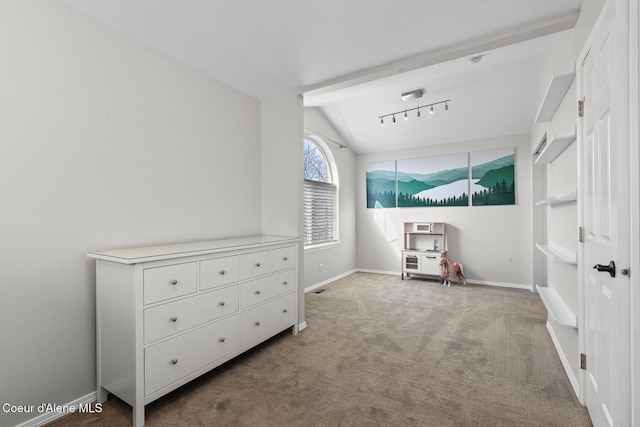 carpeted bedroom with lofted ceiling, track lighting, and baseboards