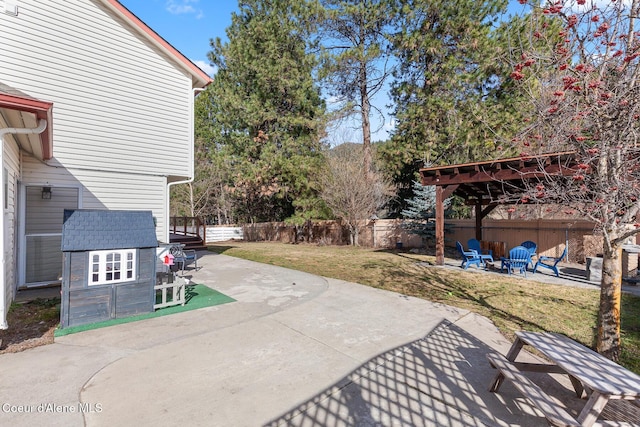 view of patio with a storage shed, a fenced backyard, and an outbuilding