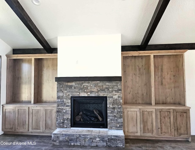 105 Backtrack Rd, Sandpoint, ID 83864 - unfurnished living room featuring beam ceiling, wood finished floors, and a stone fireplace