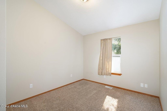 unfurnished room with baseboards, visible vents, carpet floors, and lofted ceiling