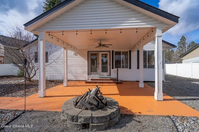 view of patio with fence, a gazebo, french doors, a fire pit, and ceiling fan