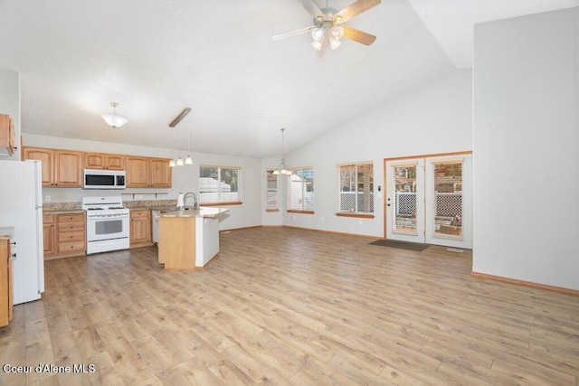 kitchen with white appliances, a ceiling fan, light wood finished floors, and a sink