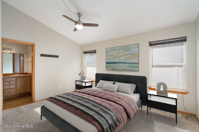 bedroom with a sink, connected bathroom, carpet, baseboards, and vaulted ceiling