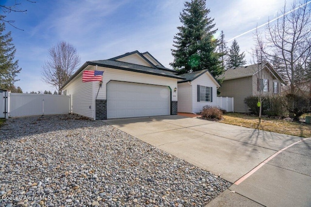 ranch-style home featuring driveway, a gate, fence, an attached garage, and brick siding