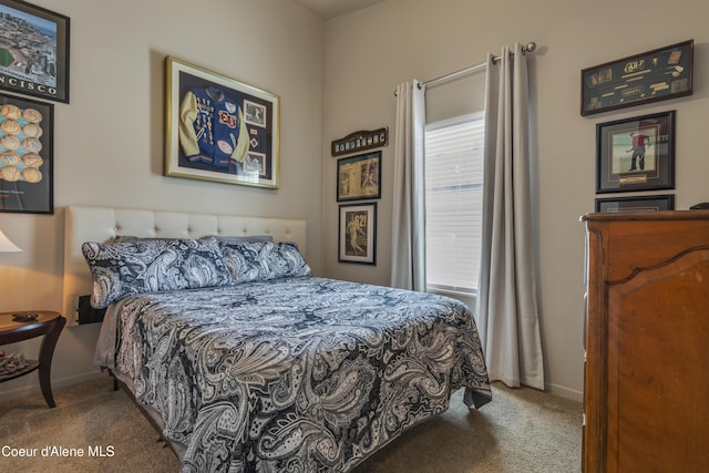 carpeted bedroom featuring baseboards and multiple windows