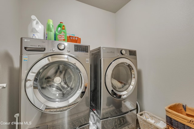 clothes washing area featuring washer and dryer and laundry area