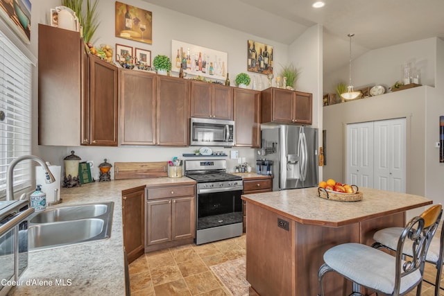 kitchen with a kitchen island, a breakfast bar, light countertops, stainless steel appliances, and a sink