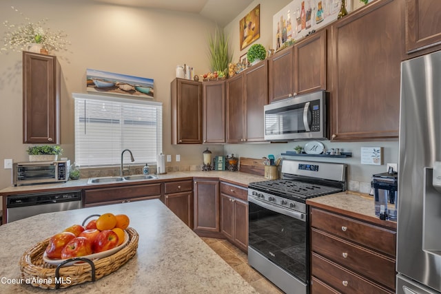 kitchen featuring a toaster, stainless steel appliances, light countertops, and a sink