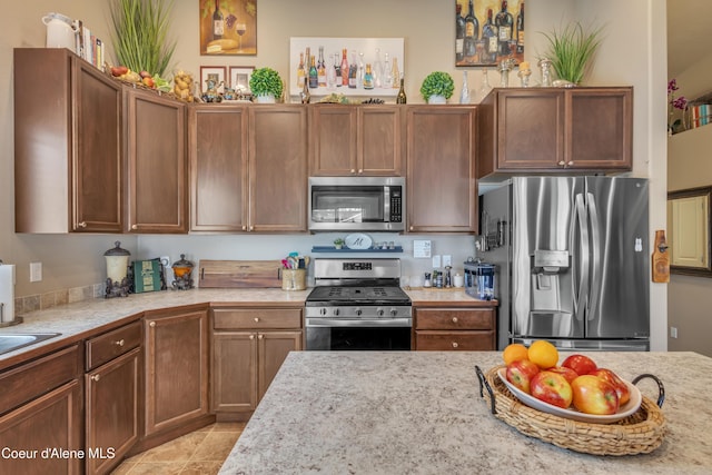 kitchen with light tile patterned floors and stainless steel appliances