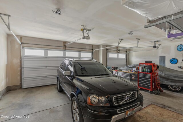 garage with electric panel and a garage door opener