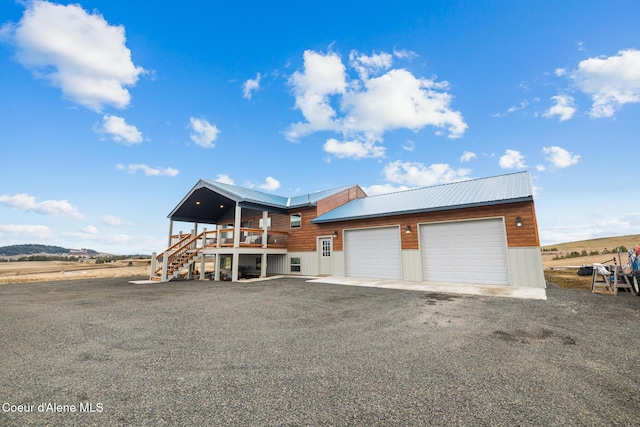 exterior space featuring metal roof, a garage, and stairway