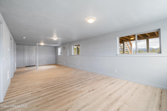 empty room featuring baseboards and light wood-style flooring