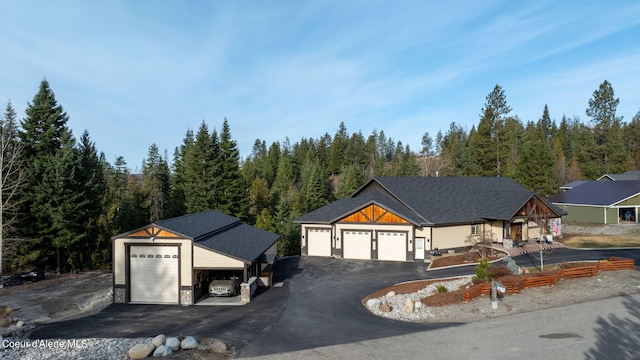 view of front facade featuring a view of trees and driveway