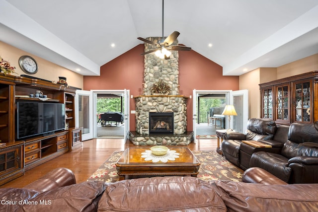 living room with high vaulted ceiling, wood finished floors, a wealth of natural light, and ceiling fan