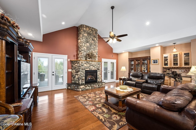 living area with french doors, high vaulted ceiling, ceiling fan, and wood finished floors