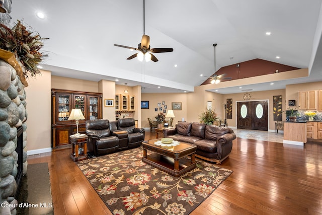 living area featuring a fireplace, high vaulted ceiling, a ceiling fan, and wood-type flooring