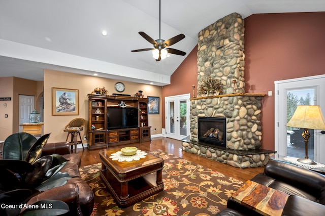 living area with a ceiling fan, wood finished floors, french doors, and high vaulted ceiling