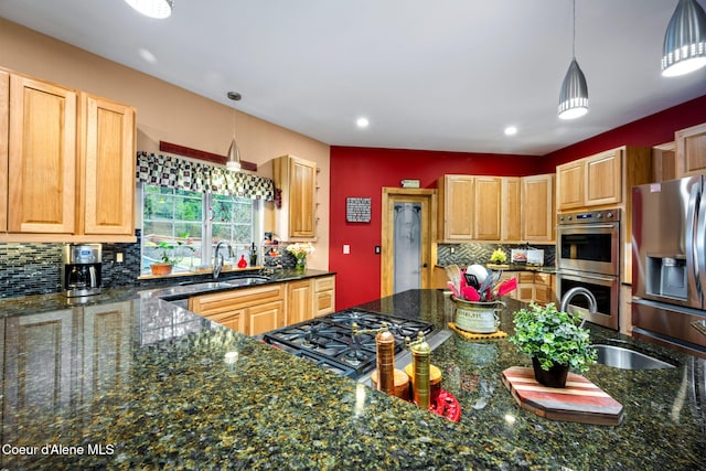 kitchen featuring a sink, backsplash, appliances with stainless steel finishes, and pendant lighting