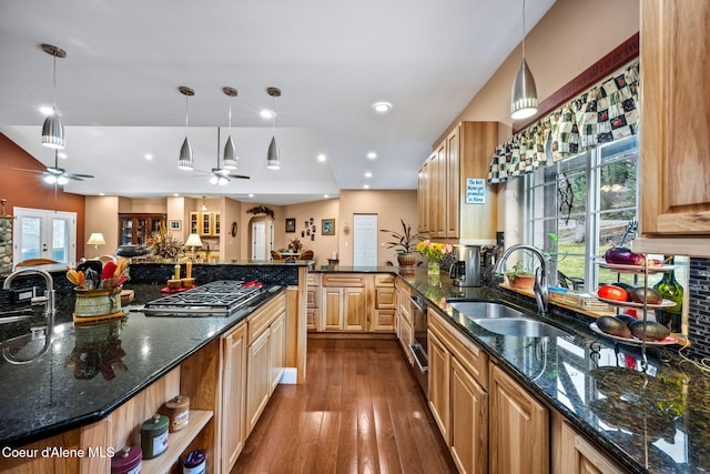 kitchen featuring a sink, open floor plan, dark wood finished floors, stainless steel gas stovetop, and ceiling fan