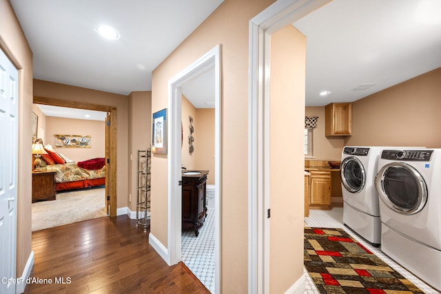 laundry room featuring hardwood / wood-style flooring, washer and clothes dryer, recessed lighting, cabinet space, and baseboards