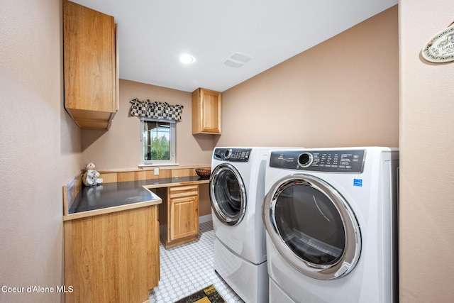 washroom with visible vents, cabinet space, and separate washer and dryer