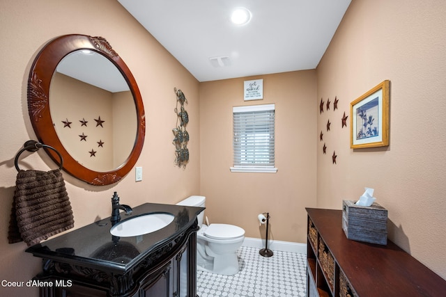 half bath with visible vents, baseboards, toilet, and vanity